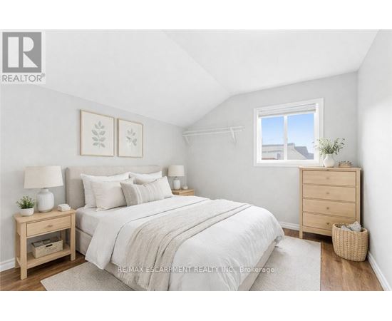 A bedroom with a bed, nightstands, and a window.