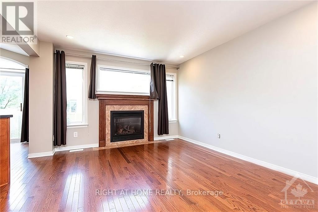 A room with a fireplace and wood flooring.