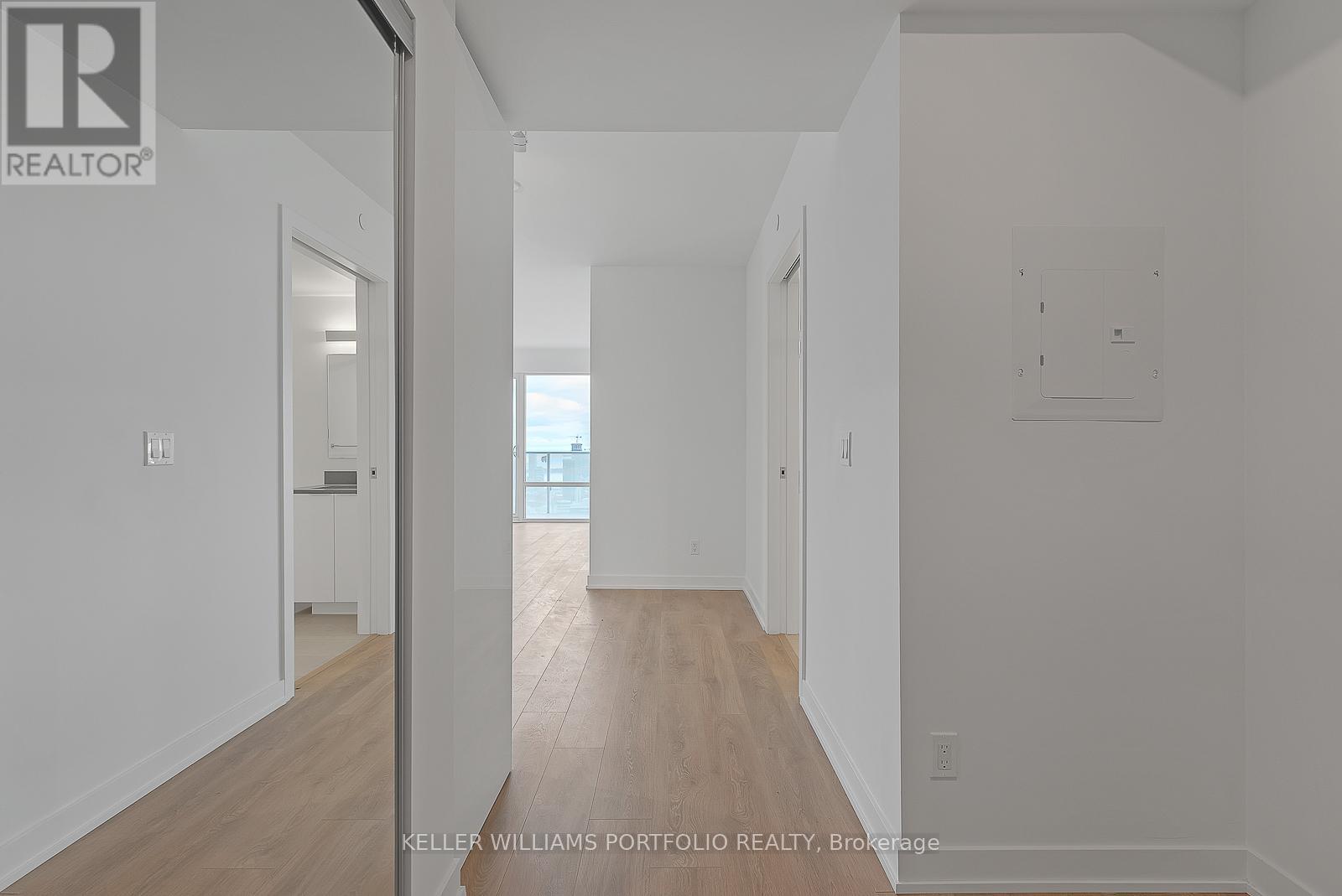 A hallway with a door on the left and a window on the right.