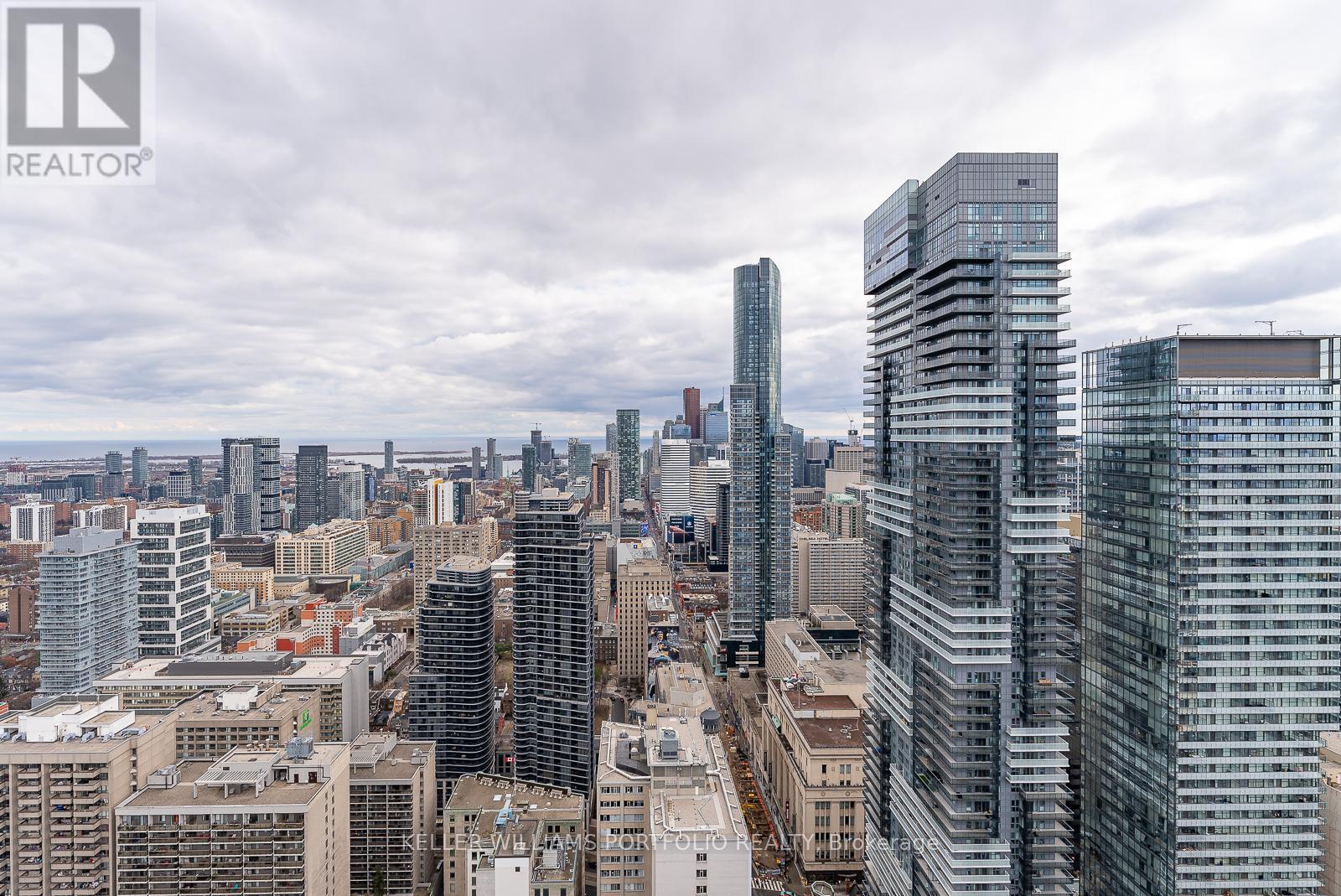 A cityscape with tall buildings and a cloudy sky.