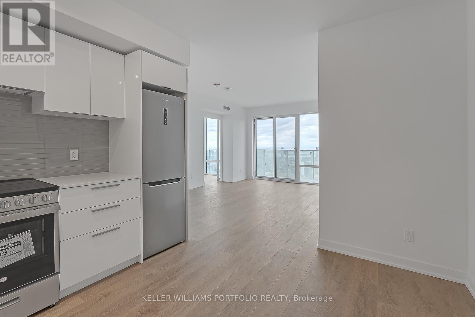 A modern kitchen with white cabinets and stainless steel appliances.
