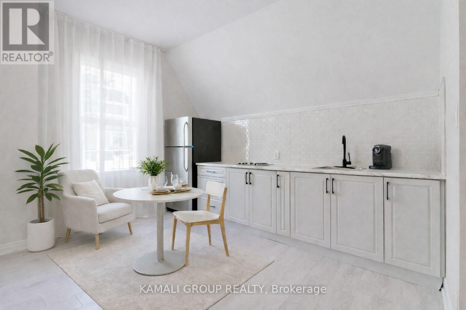 A white kitchen with a table and chairs.