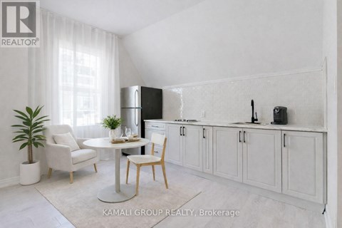 A white kitchen with a table and chairs.
