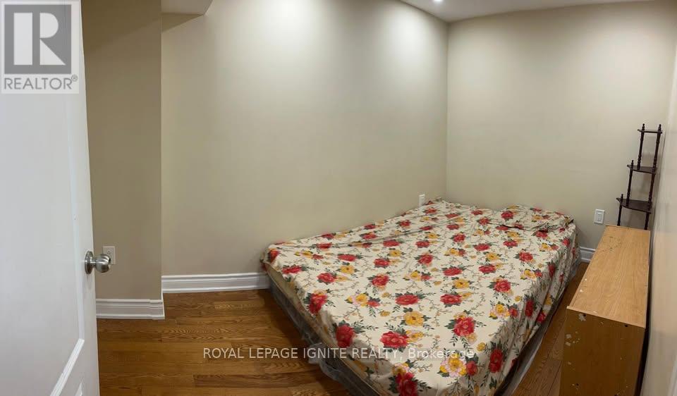 A bedroom with a floral bedspread and a bed against the wall.