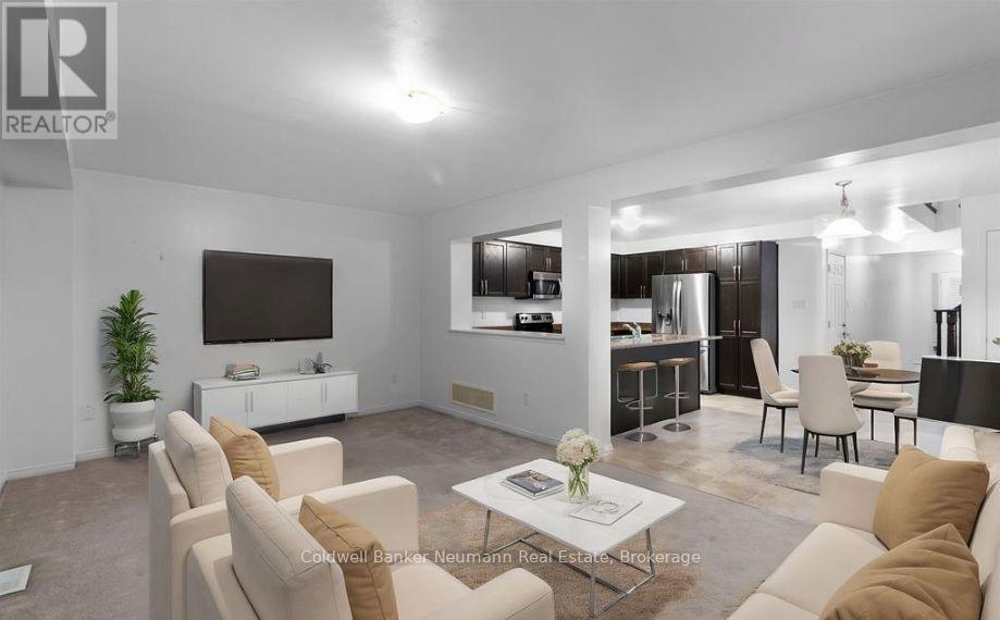 A living room with a white sofa set and a television.