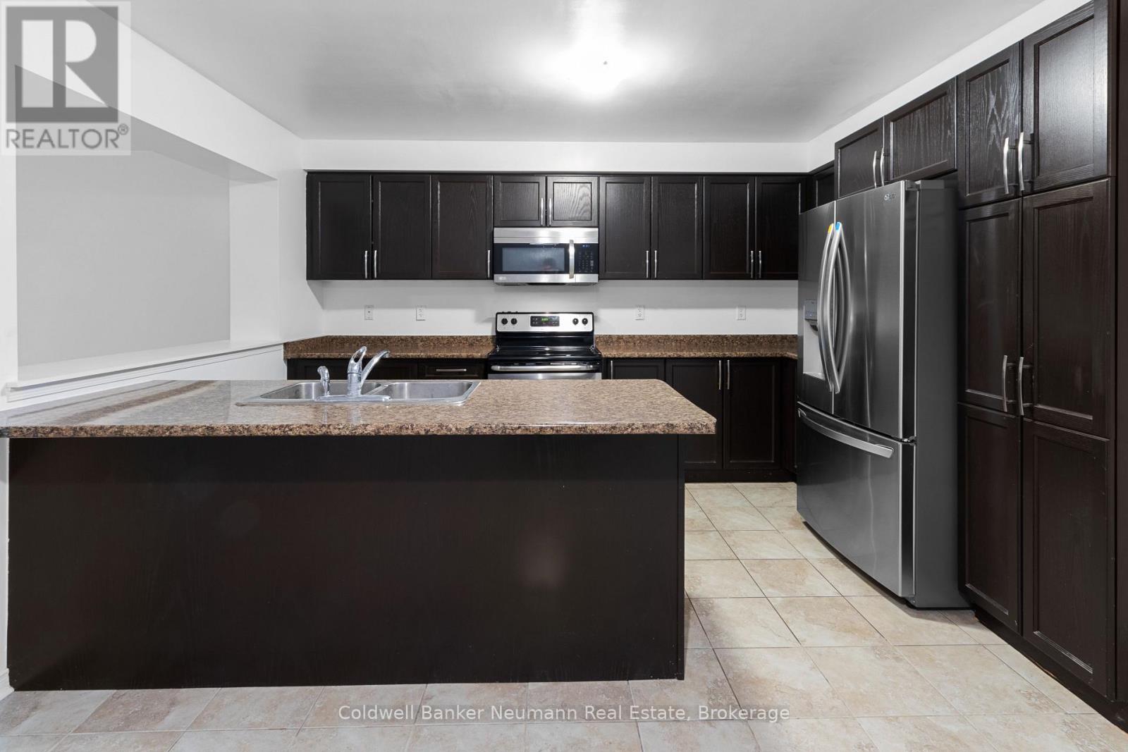 A kitchen with a brown counter top and stainless steel appliances.