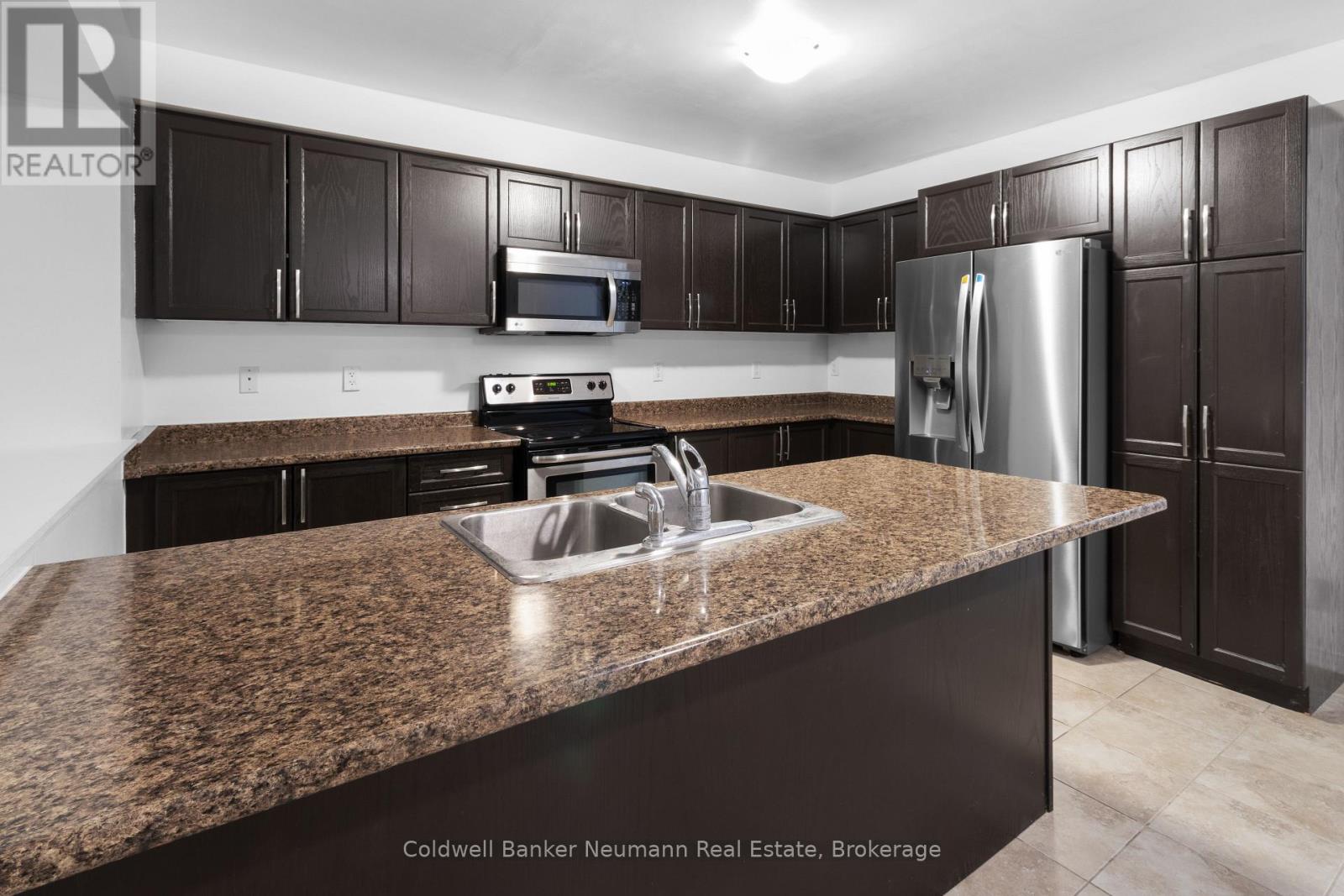 A kitchen with brown cabinets and a granite countertop.