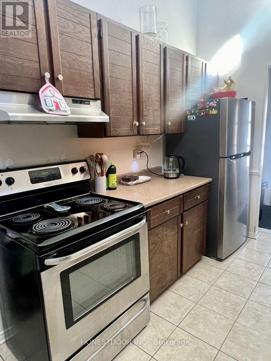 A kitchen with a stove top oven and a refrigerator.