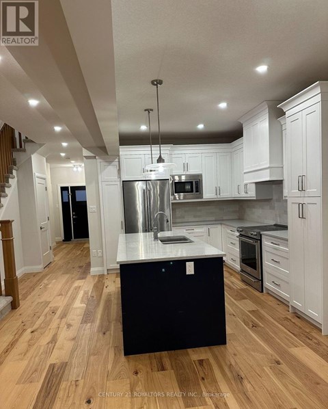 A modern kitchen with white cabinets and a black island.