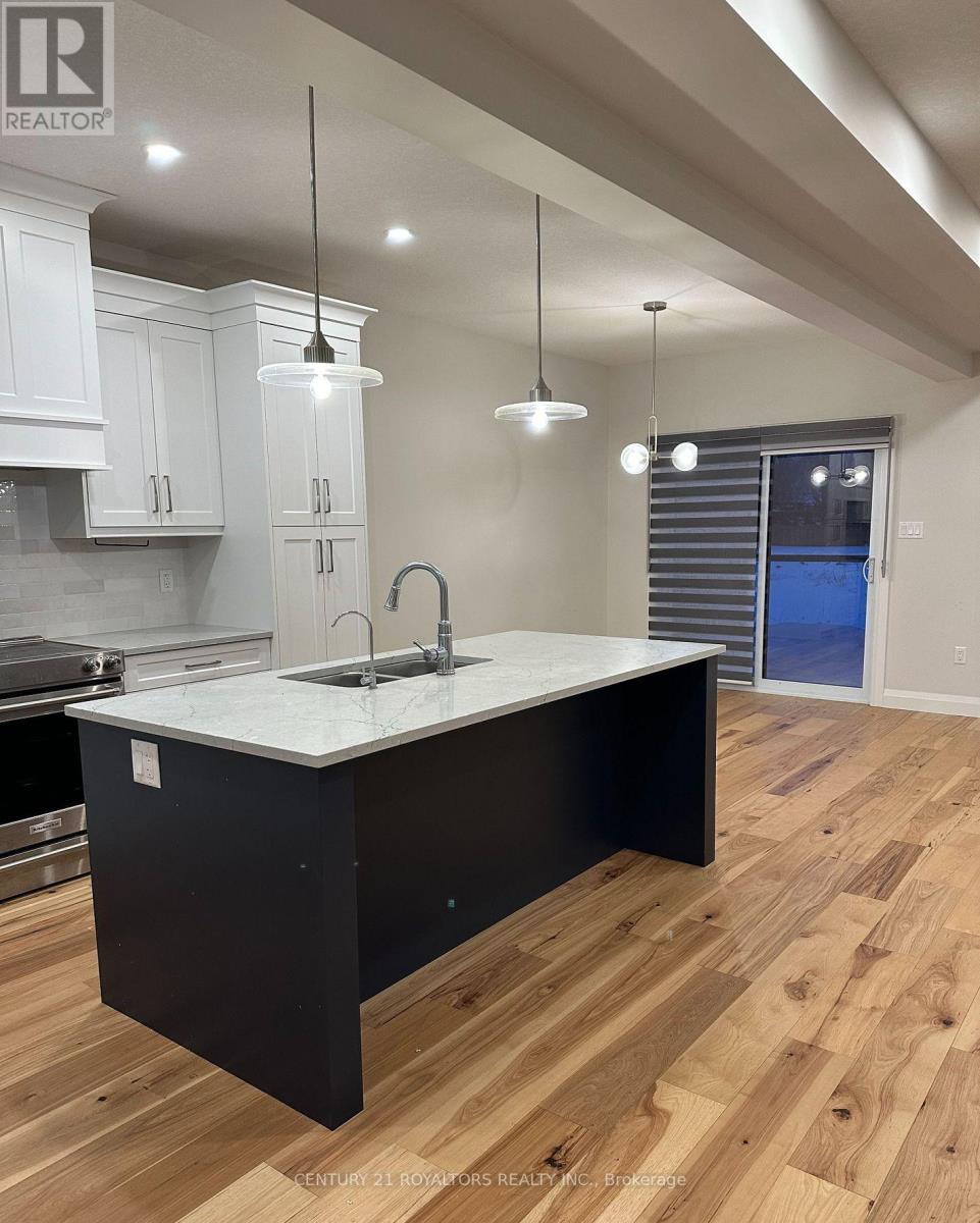 A modern kitchen with a large island and wooden floors.