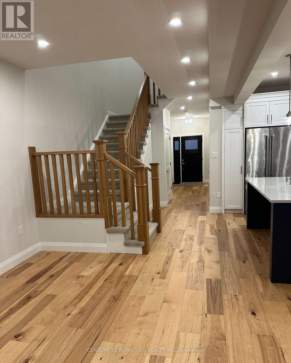 A wooden staircase with a glass balustrade leads up to a second floor.