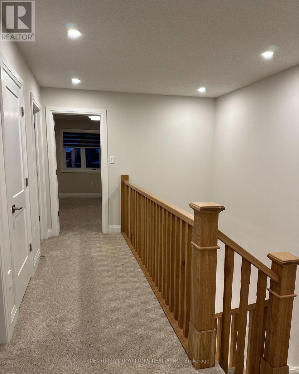 A hallway with a carpeted floor and a wooden railing.