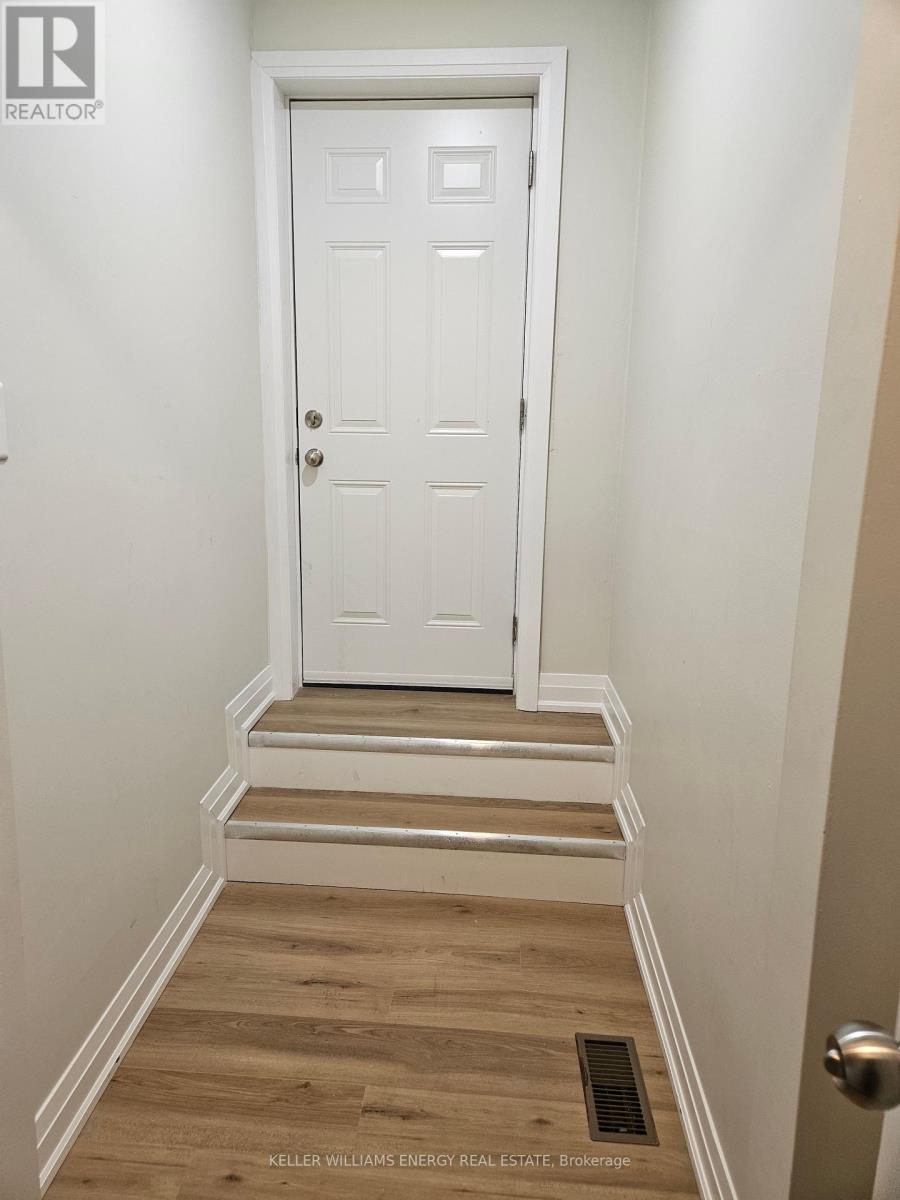 A white door is at the end of a hallway with wooden floors.