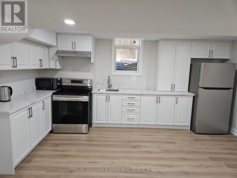 A kitchen with white cabinets and a stainless steel refrigerator.