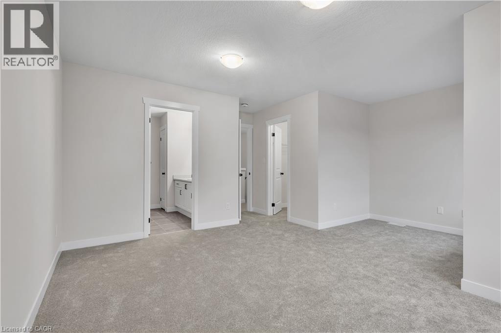 A spacious room with a carpeted floor and white walls.