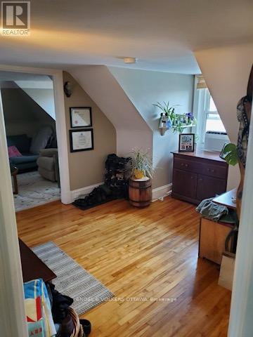 A living room with a couch, a dog, and a wooden floor.