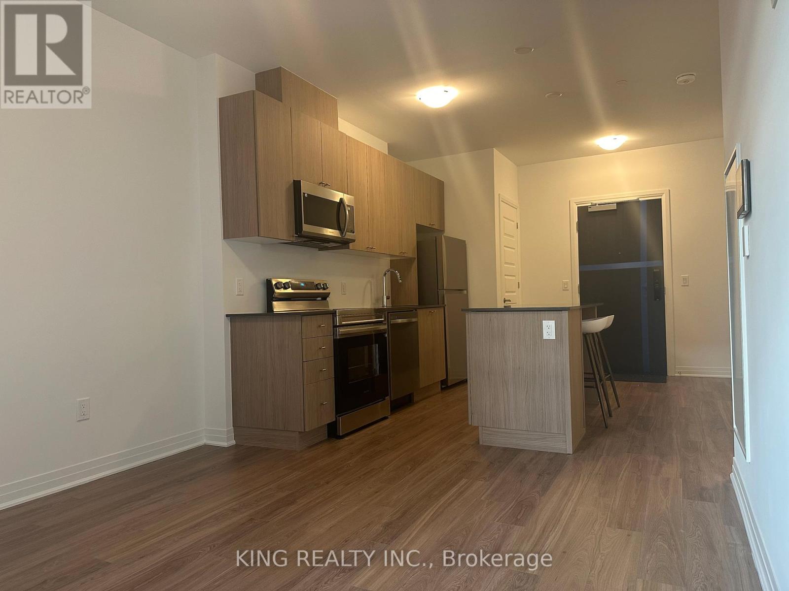 A kitchen with wooden cabinets and a microwave.