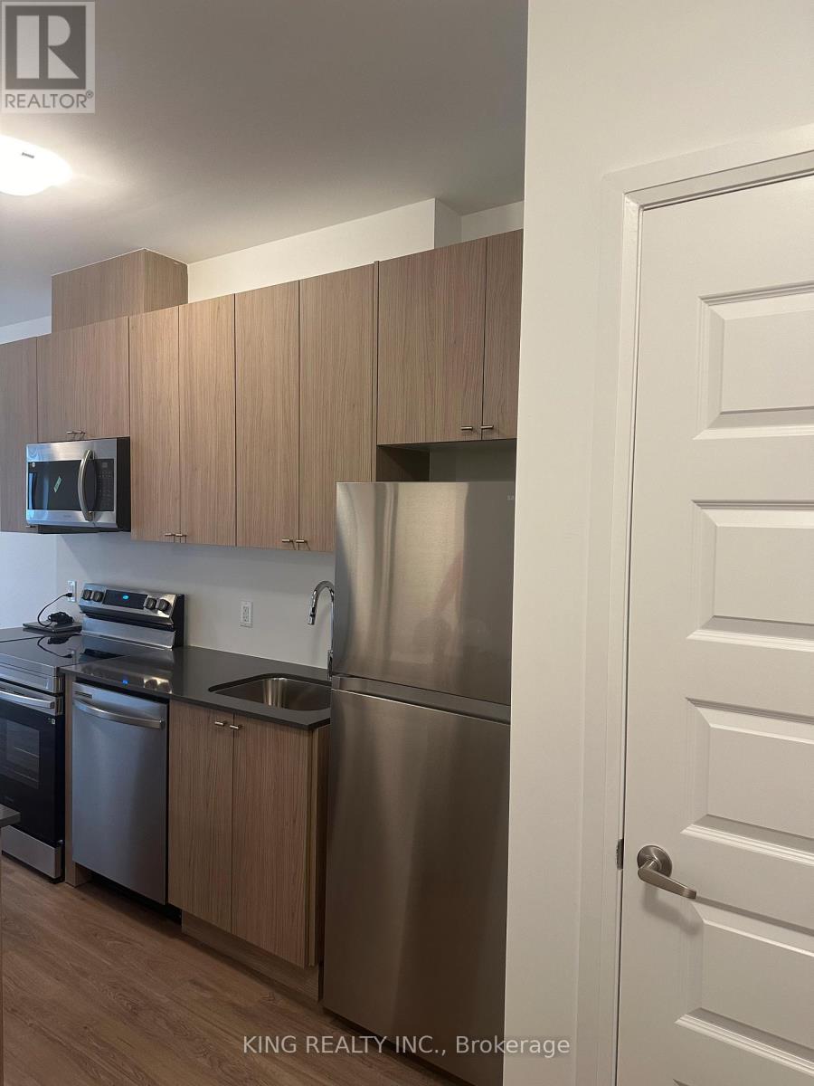 A kitchen with a white door and a stainless steel refrigerator.