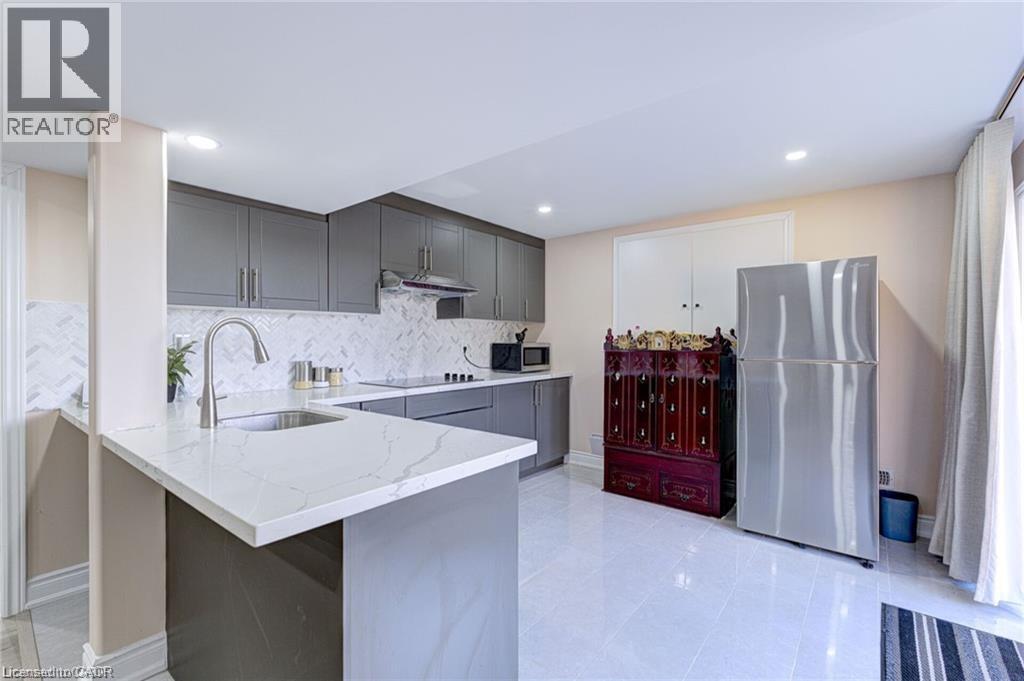A modern kitchen with a marble countertop and stainless steel appliances.
