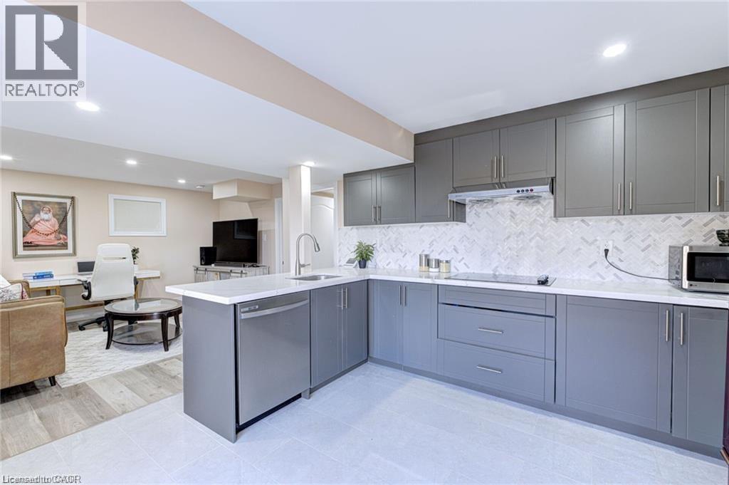 A modern kitchen with grey cabinets and a white countertop.