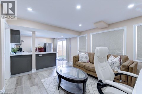 A living room with a white chair and a brown couch.