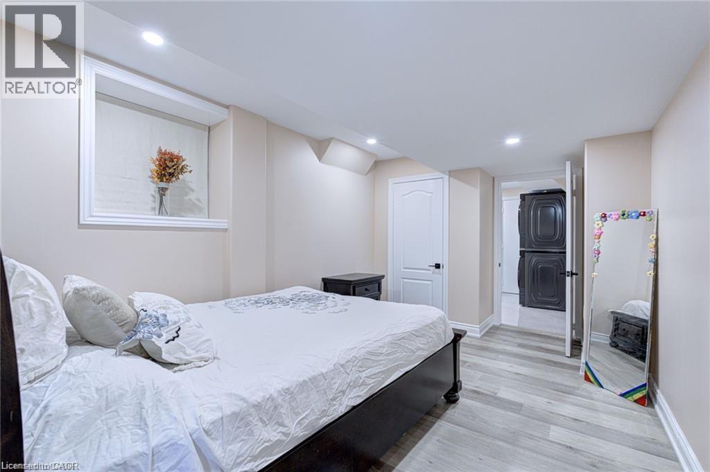 A bedroom with a bed, nightstand, and a door leading to another room.
