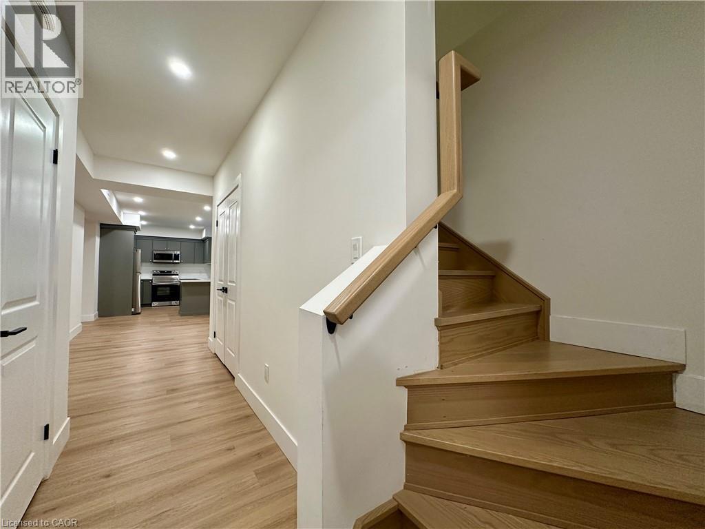 A wooden staircase with a white wall on one side and a door on the other.