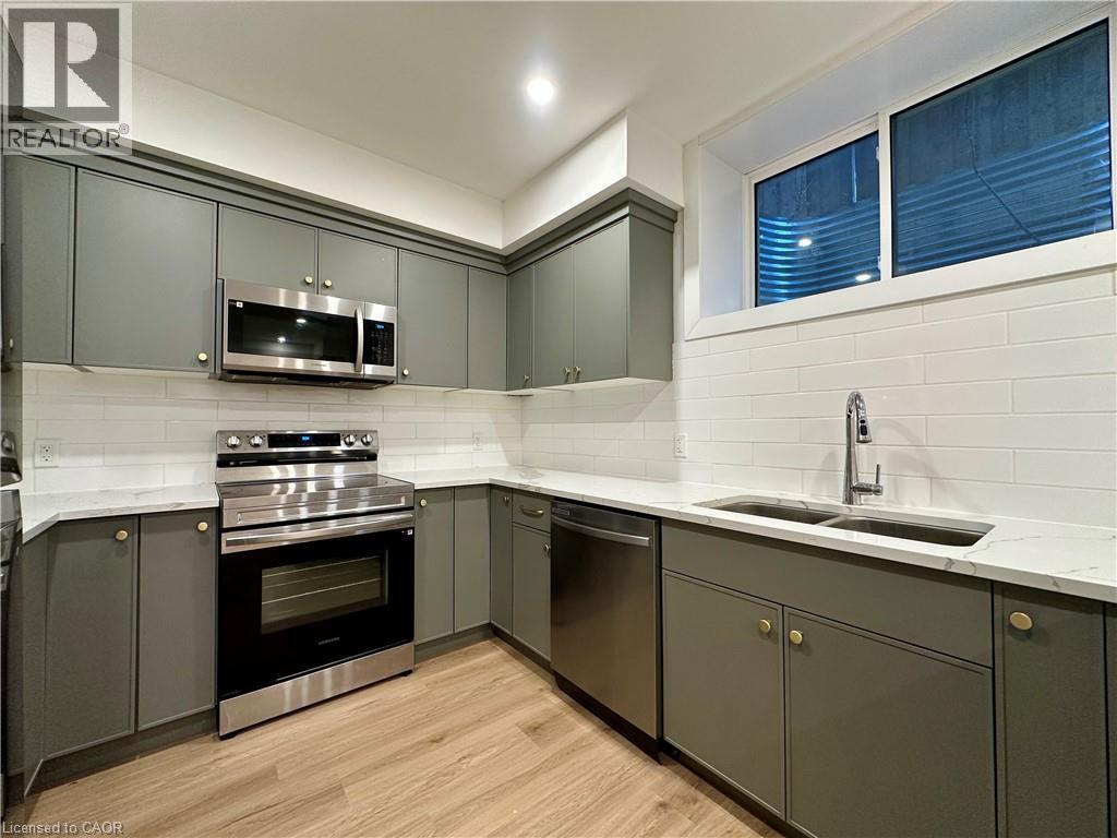 A modern kitchen with a stainless steel oven and microwave.