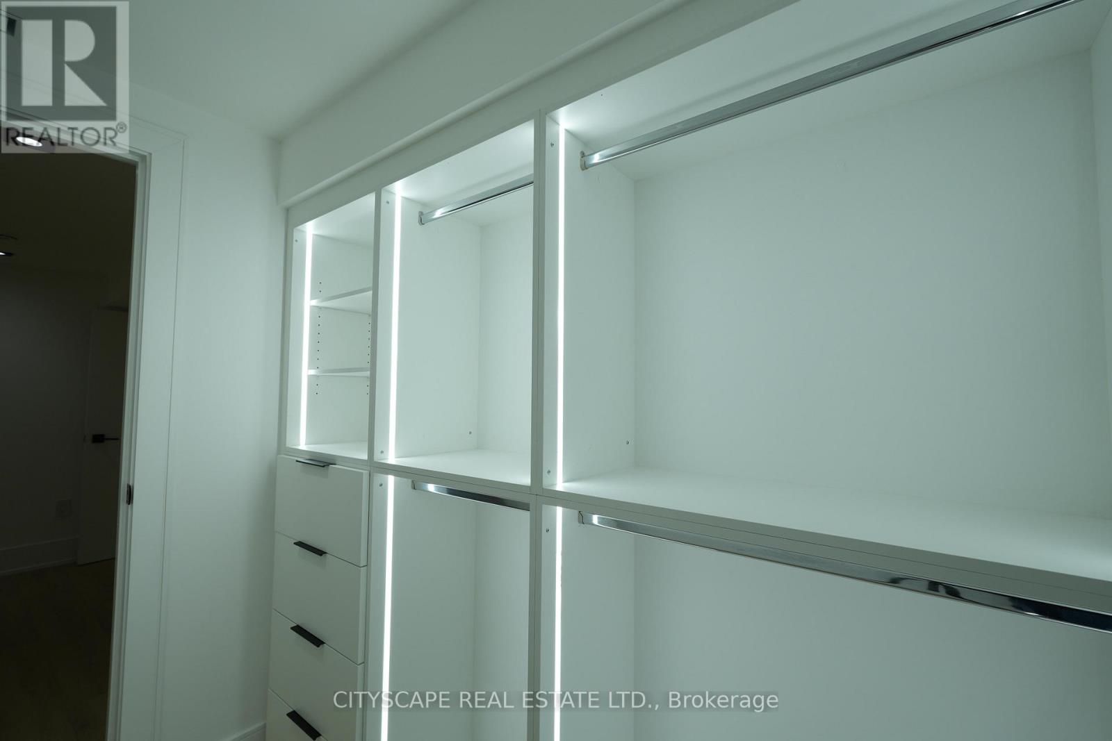A white brokerage office with a glass wall and shelves.