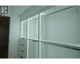 A white brokerage office with a glass wall and shelves.