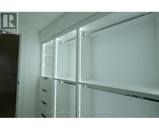A white brokerage office with a glass wall and shelves.