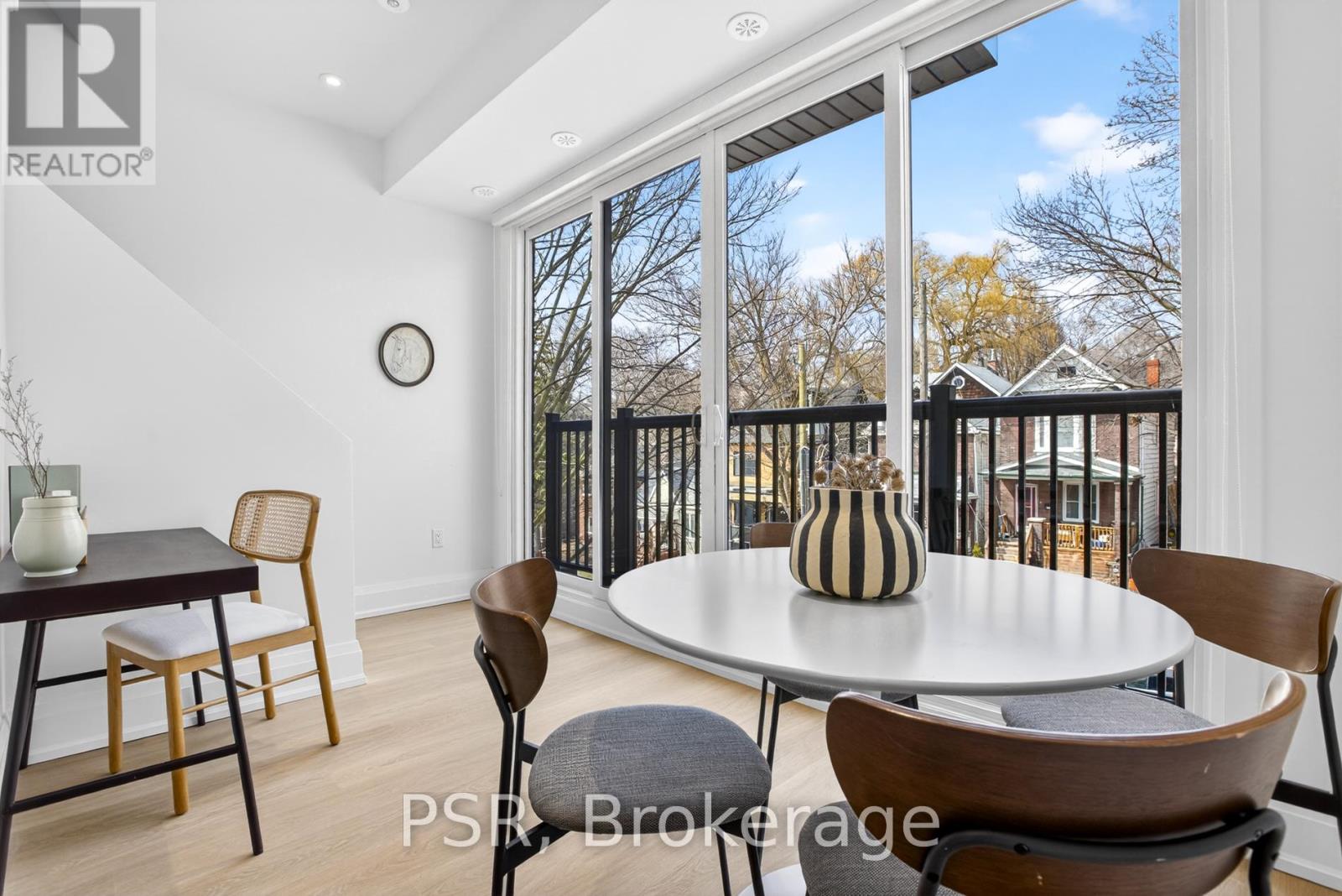 A dining room with a table and chairs and a view of the backyard through the sliding glass doors.
