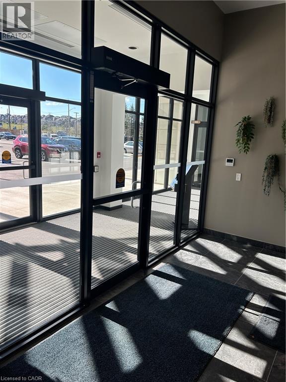 A glass door with a black frame and a black mat on the floor.