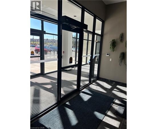 A glass door with a black frame and a black mat on the floor.