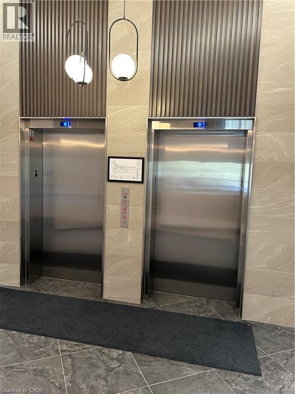 Two elevators in a building with a sign on the wall.