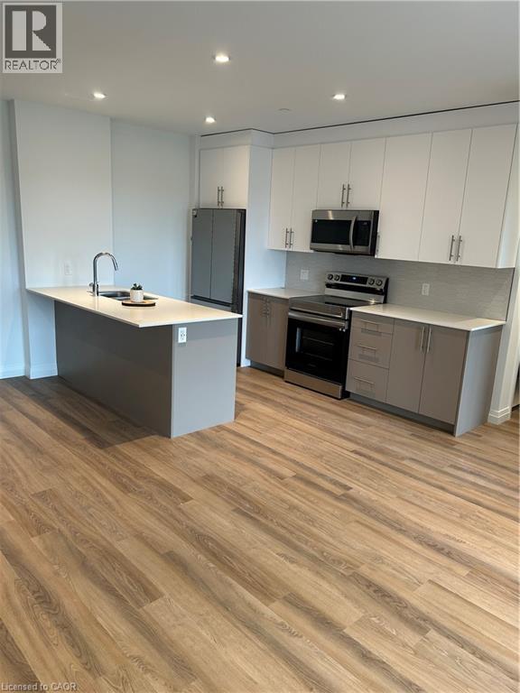 A kitchen with a wooden floor and white cabinets.