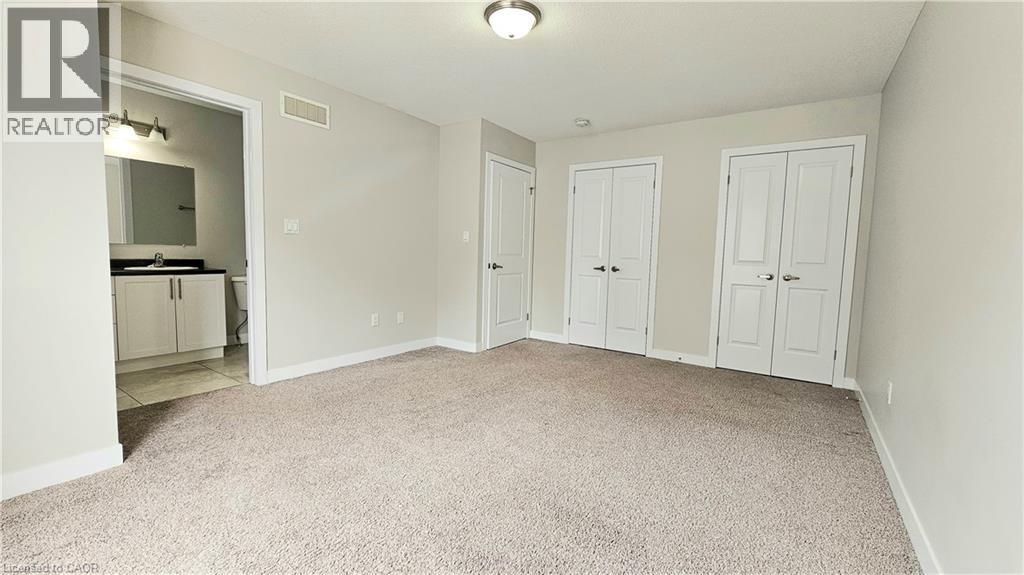 A bedroom with a white wardrobe and a carpeted floor.