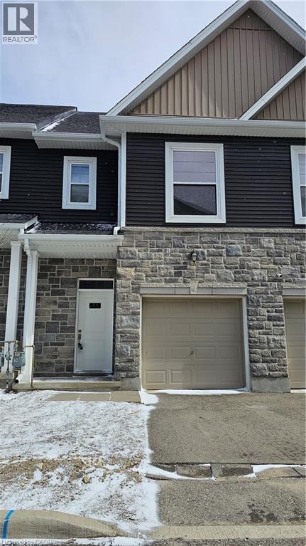 A house with a stone wall and a garage door.