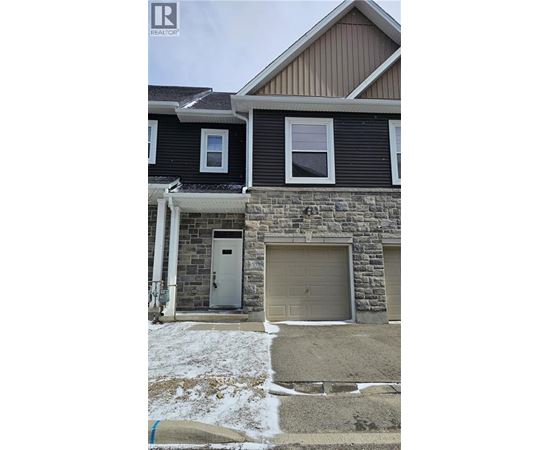 A house with a stone wall and a garage door.