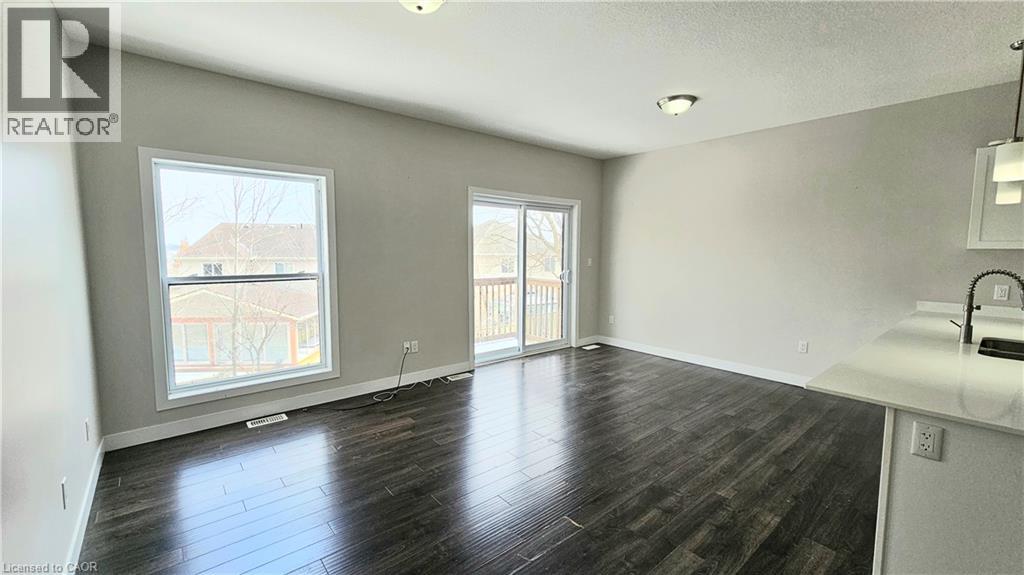 A spacious room with wooden flooring and a large window.