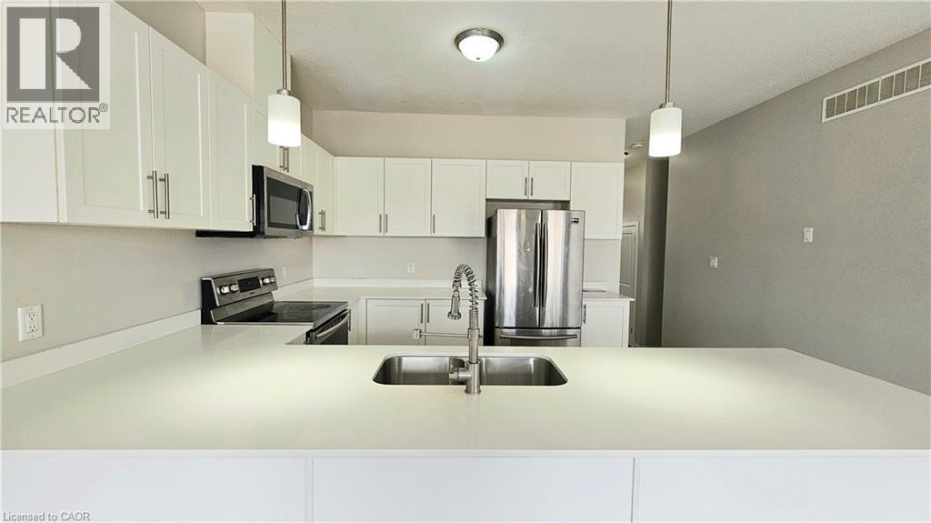 A kitchen with white cabinets and a stainless steel refrigerator.