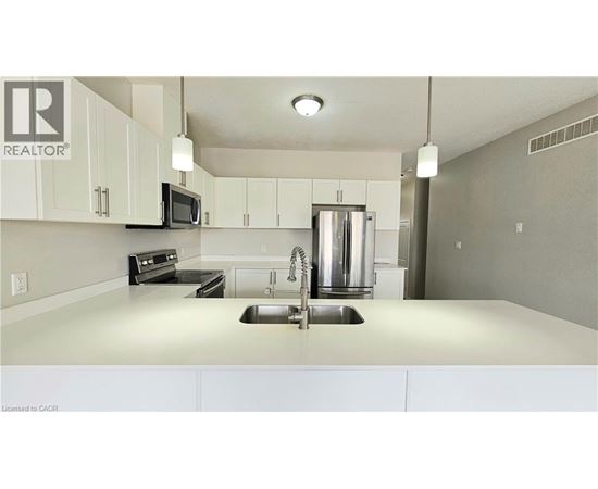 A kitchen with white cabinets and a stainless steel refrigerator.