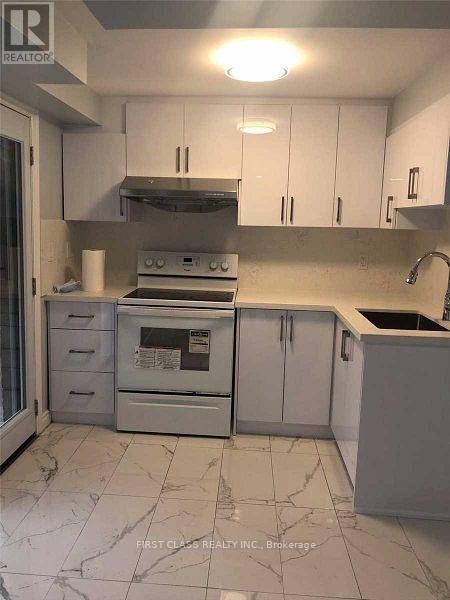 A kitchen with white cabinets and a stove top oven.
