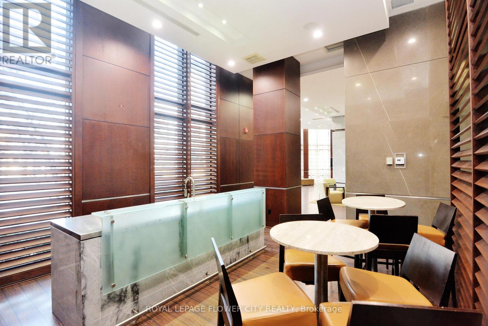 A modern office space with a glass partition and wooden furniture.