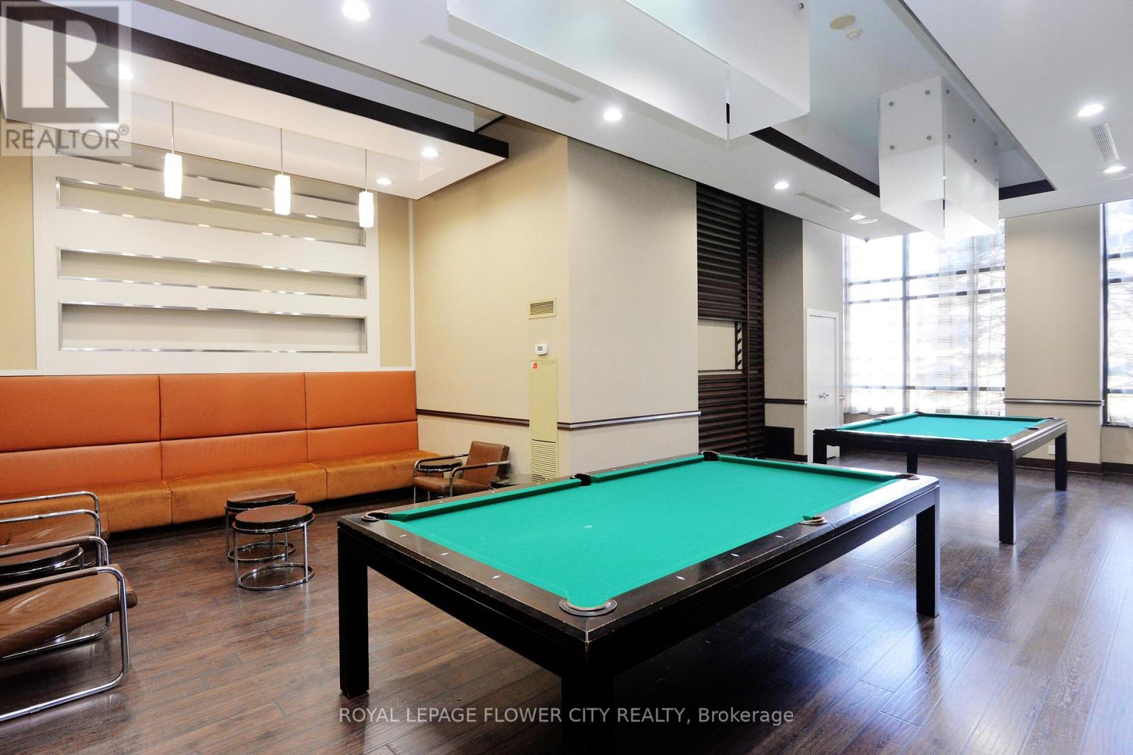A pool table in a room with a couch and chairs.