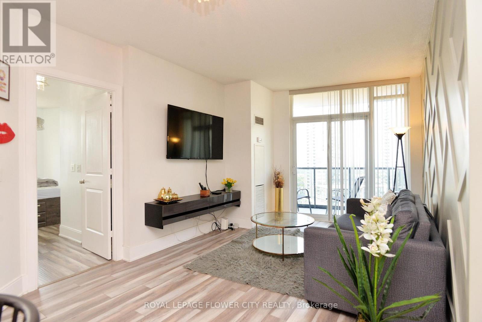 A living room with a grey sofa and a glass coffee table.