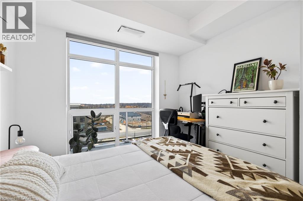 A bedroom with a large bed and a desk with a chair.