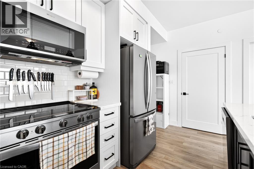 A modern kitchen with a black stove top oven and white cabinets.
