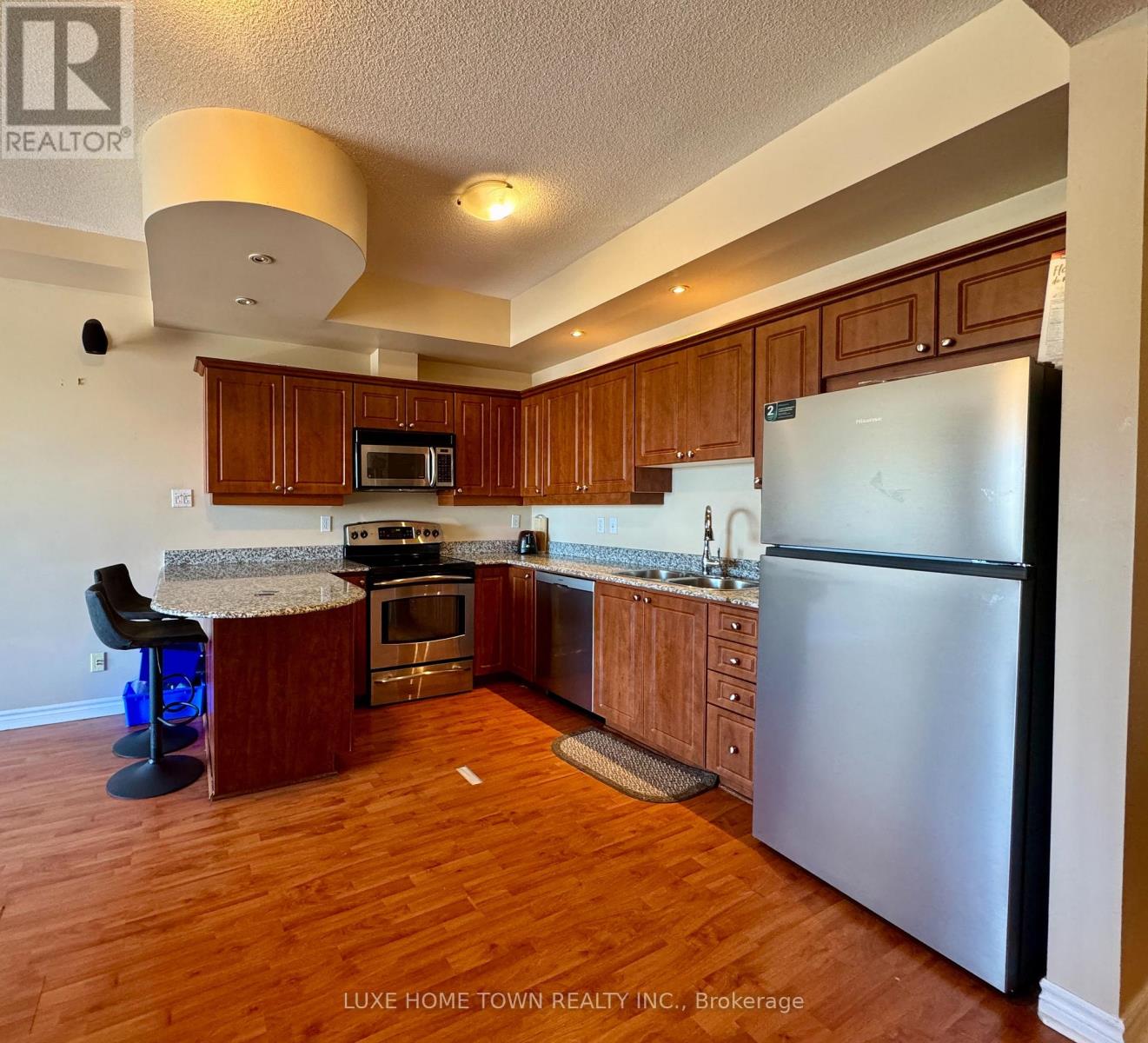 A kitchen with wooden cabinets and a refrigerator.