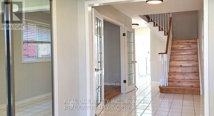 A hallway with a staircase and a glass door.